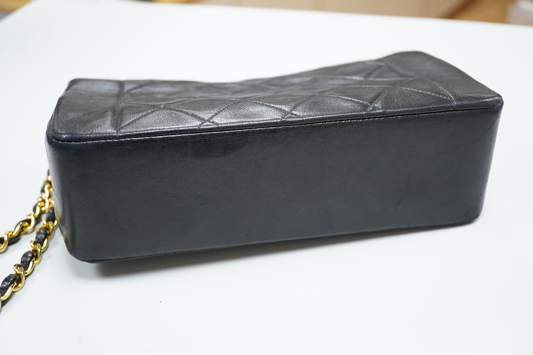 A late 1980’s Chanel black leather Diana shoulder bag with original dust cover and bag, Chanel authenticity card numbered 1944645, interior date code rubbed, 23cm wide, Provenance: Purchased by the vendor, 26 Old Bond St